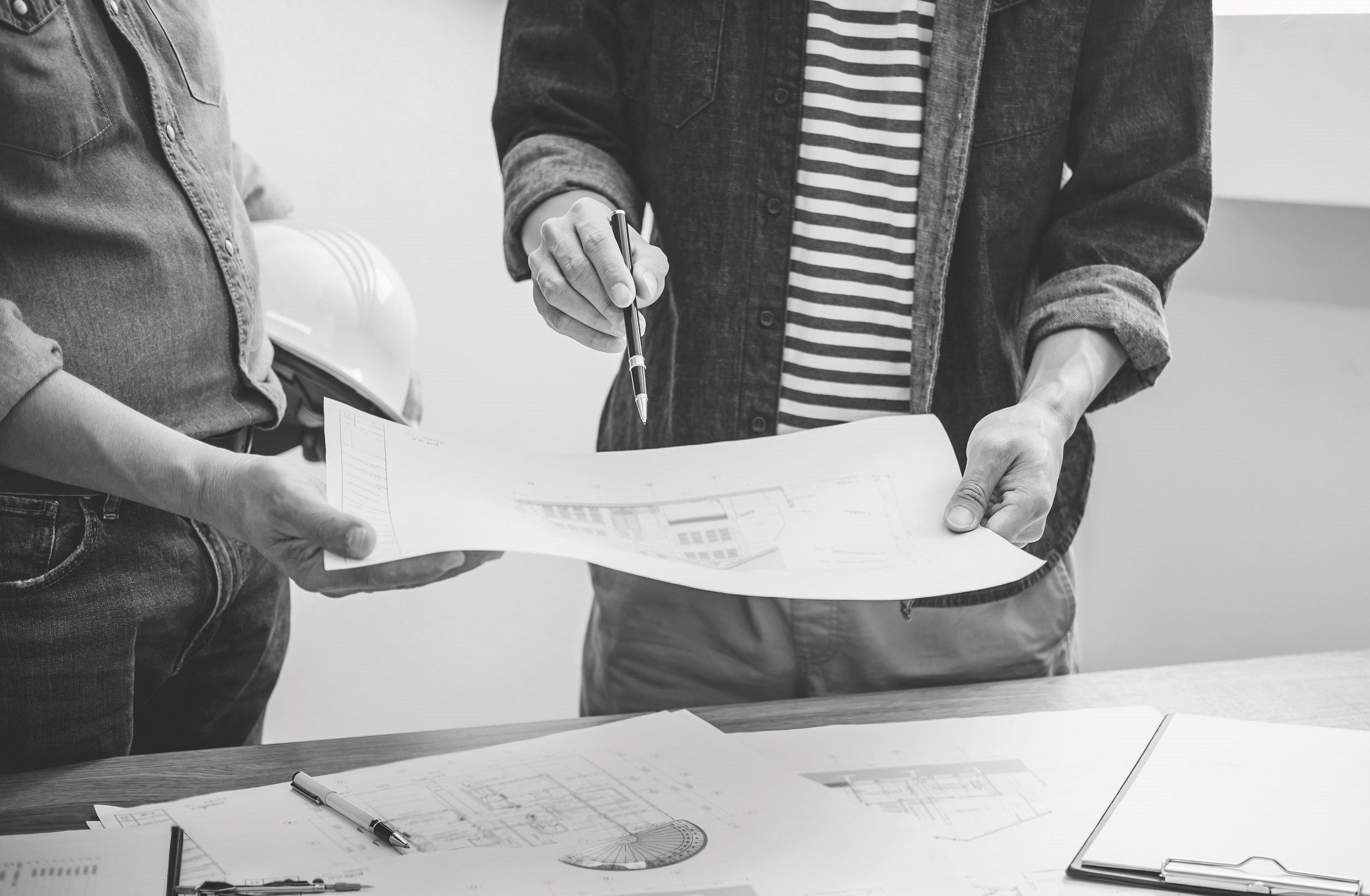 Menschen halten einen Bauplan in der Hand